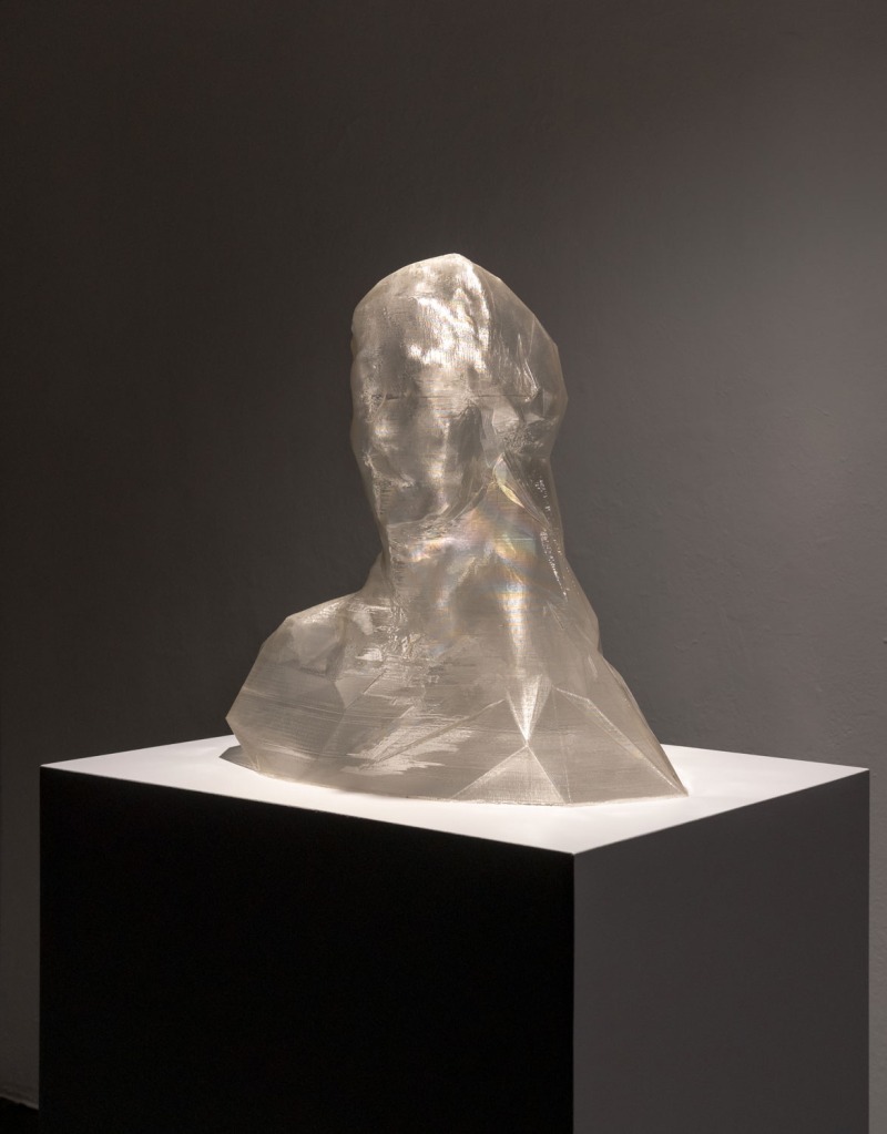 A translucent faceted bust on a black pedestal